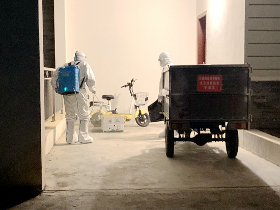 副本4:00 台城街道防疫工作人员身穿防护服,背着装有消毒水的喷雾器对重点人员住所及周边进行环境消杀。随后,他们将开展环境检测、垃圾转运等工作。.jpg