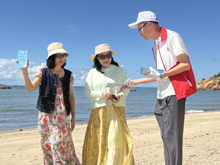 图为净滩志愿者向游客群众派发宣传单.jpg