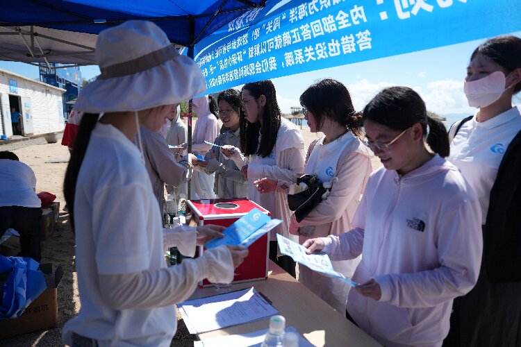 图为志愿者和群众一起参观净滩活动系列主题展板.jpg