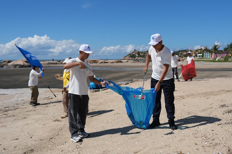 图为青年志愿者在收拾海滩上的垃圾1.jpg
