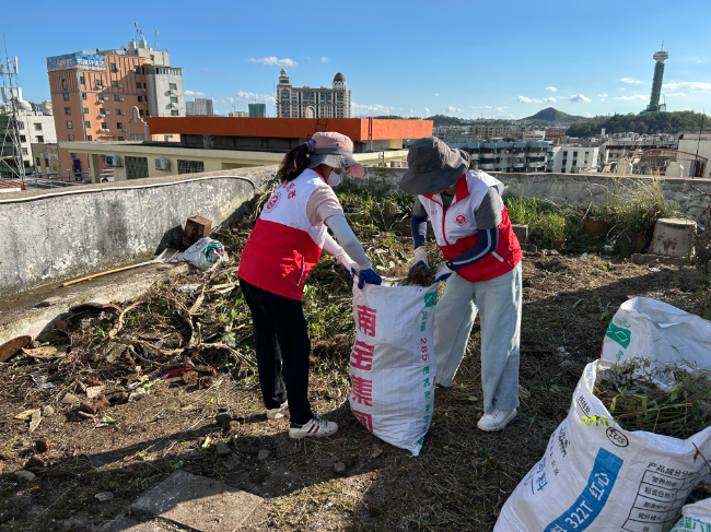 大湾集团党员干部清理居民楼顶杂草垃圾.jpg